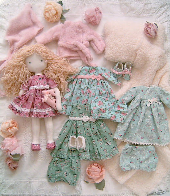 Carol handmade blonde Waldorf-style fabric doll with a floral dress and a collection of handmade doll clothes and accessories